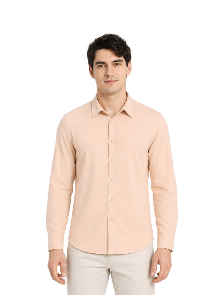 Hombre vistiendo una camisa de manga larga color arena con cuello y botones.