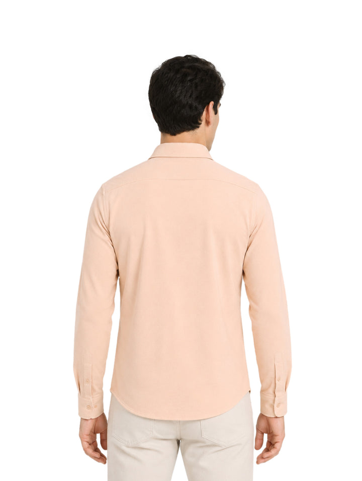 Hombre vistiendo una camisa de manga larga color arena con cuello y botones.