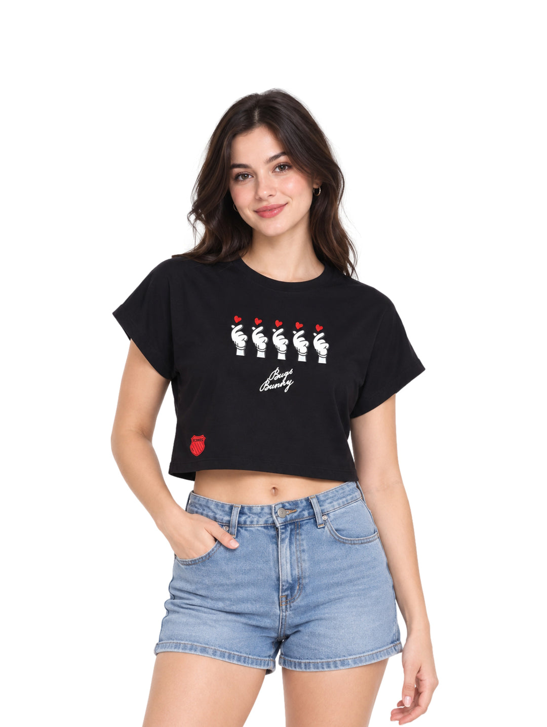 Mujer vistiendo playera crop top color negro con estampado gráfico y shorts de mezclilla azules.