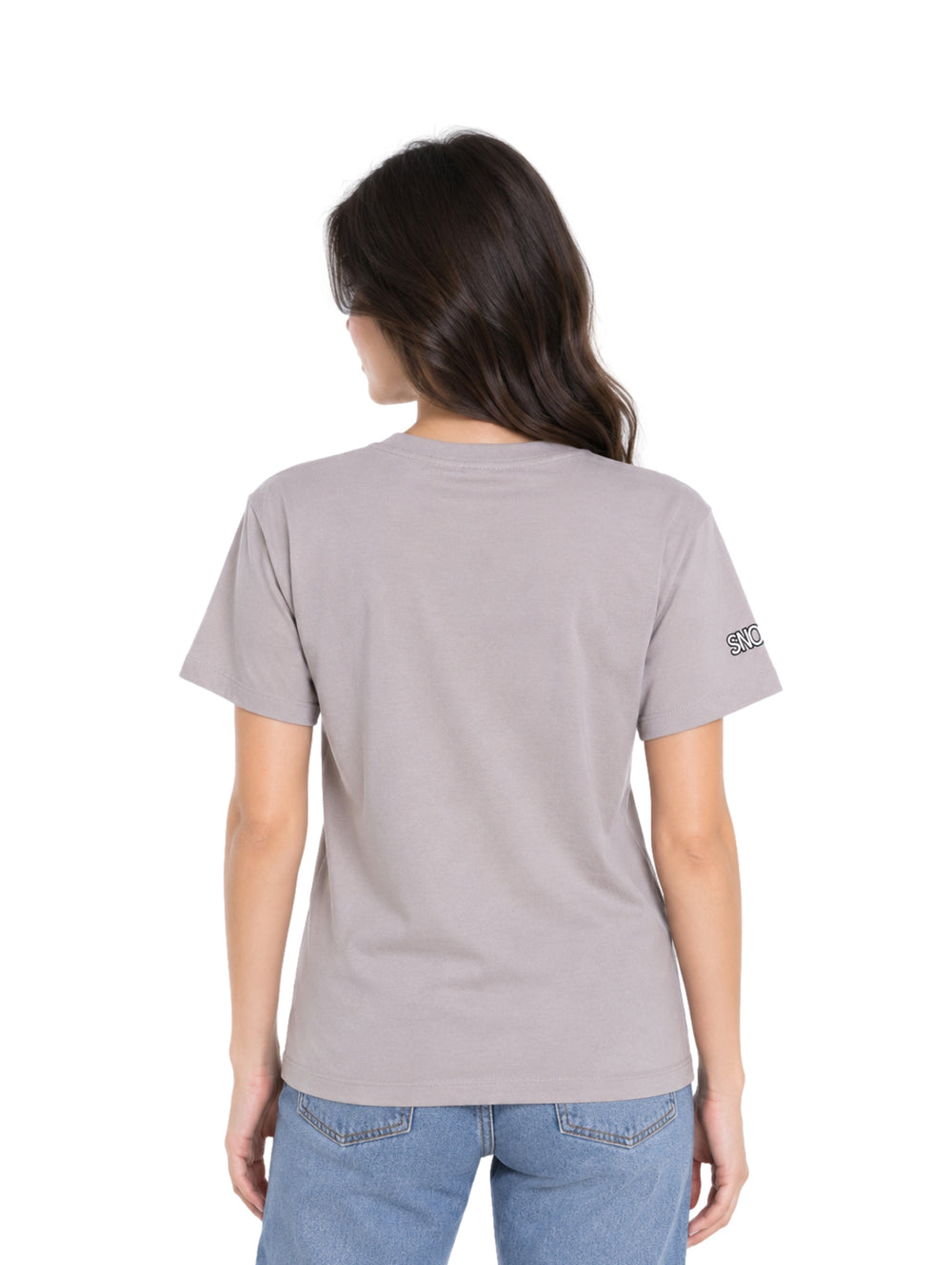Mujer vistiendo playera gris K-Swiss con estampado de Snoopy y jeans azules.