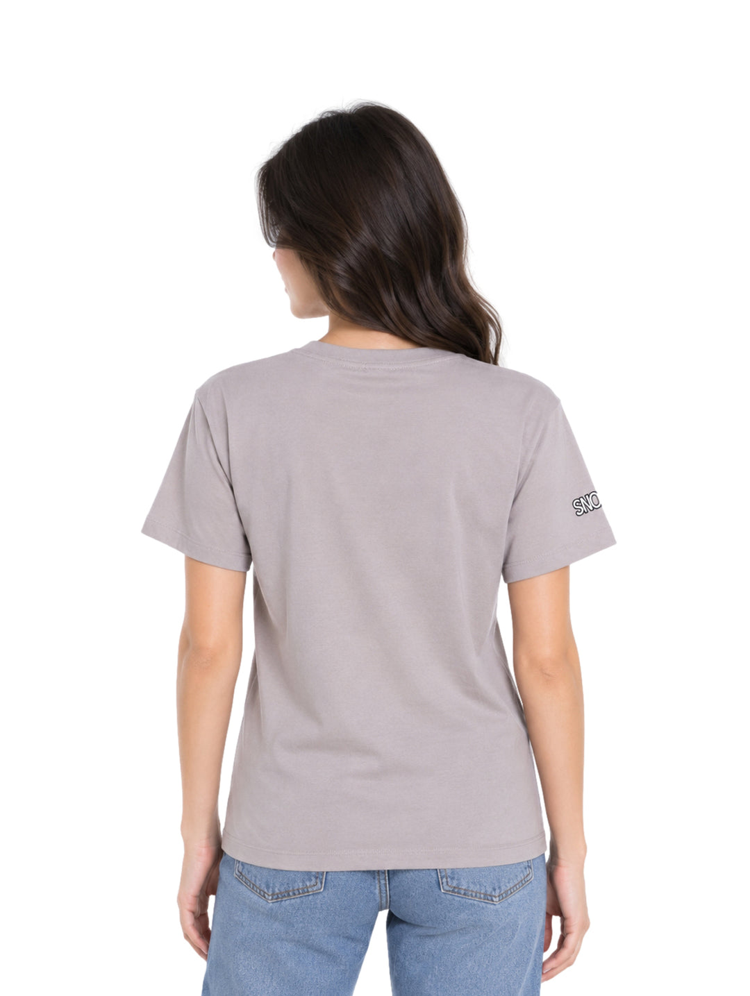 Mujer vistiendo playera gris K-Swiss con estampado de Snoopy y jeans azules.