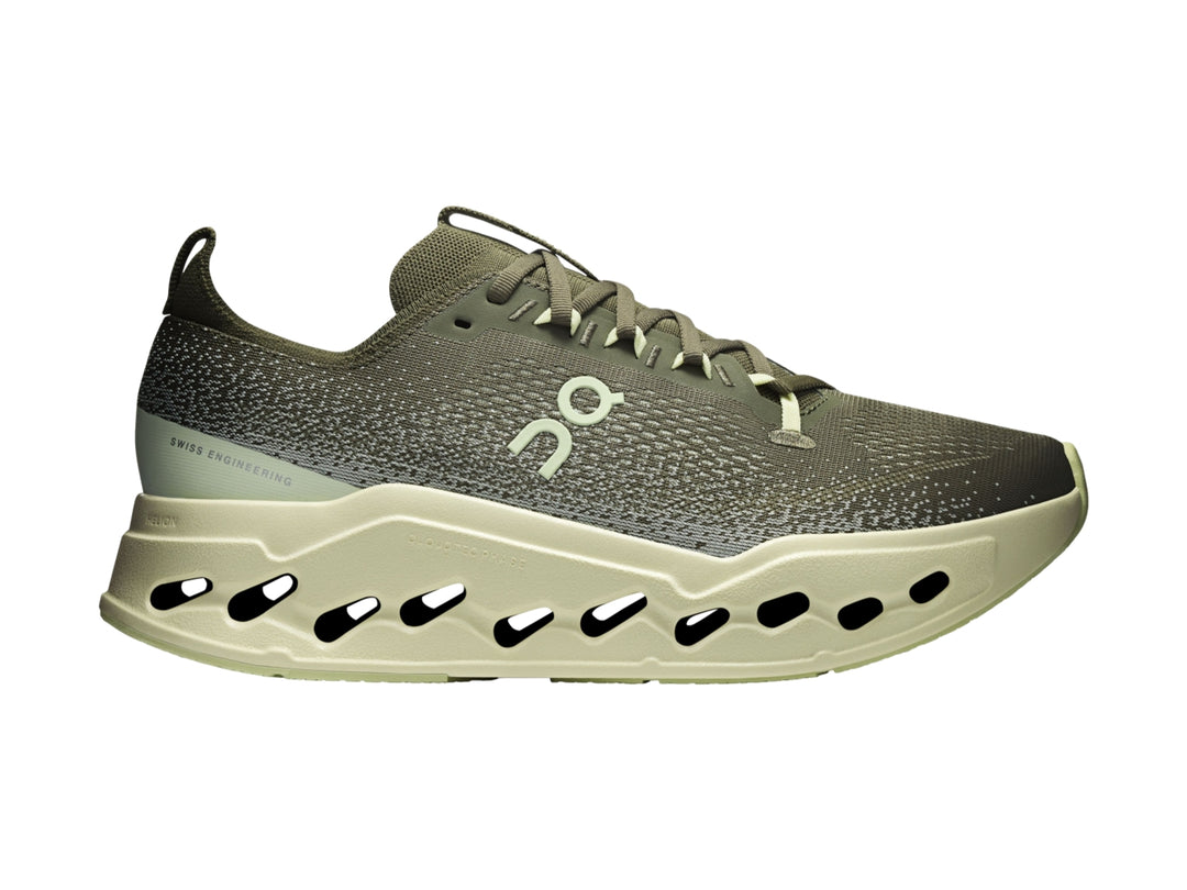 Tenis deportivos On Cloud color verde oliva con suela gruesa y perforada en tono verde claro.