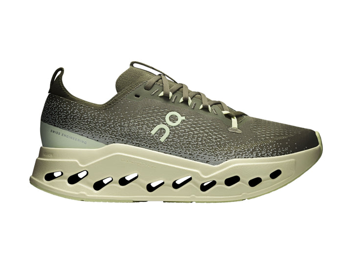 Tenis deportivos On Cloud color verde oliva con suela gruesa y perforada en tono verde claro.