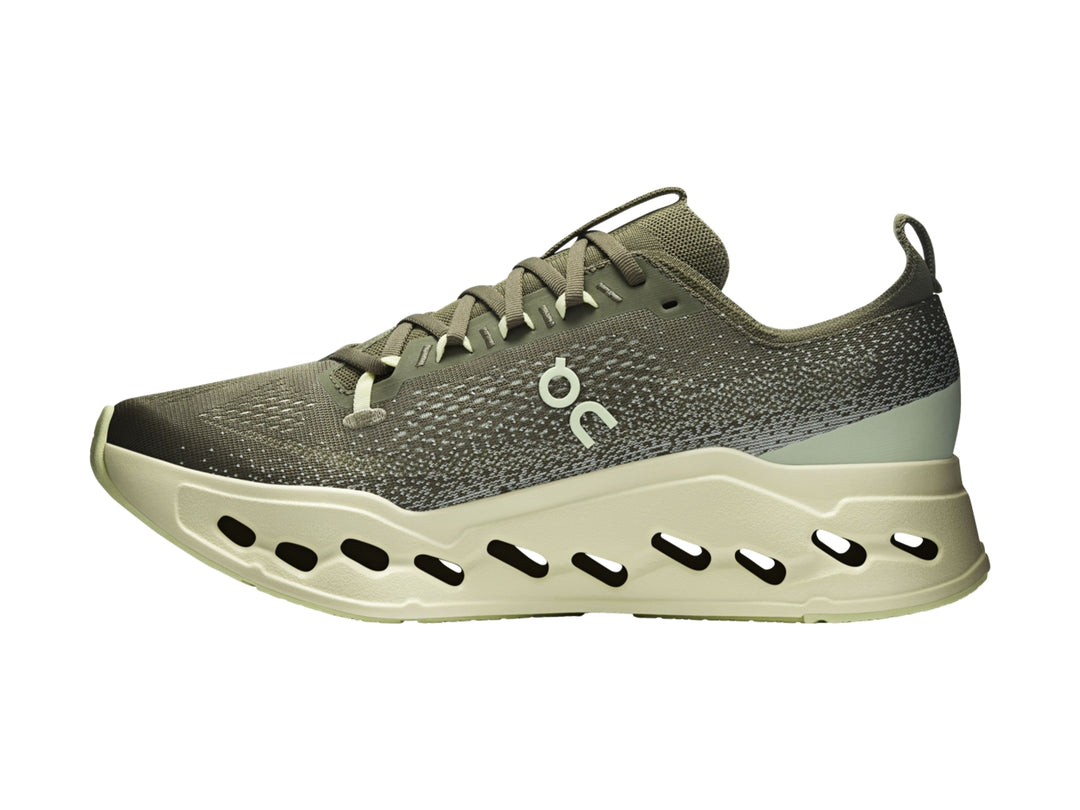 Tenis deportivos On Cloud color verde oliva con suela gruesa y perforada en tono verde claro.