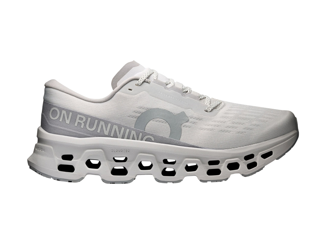 Tenis deportivos On Cloudmonster 3 en color gris claro con suela amortiguada característica.