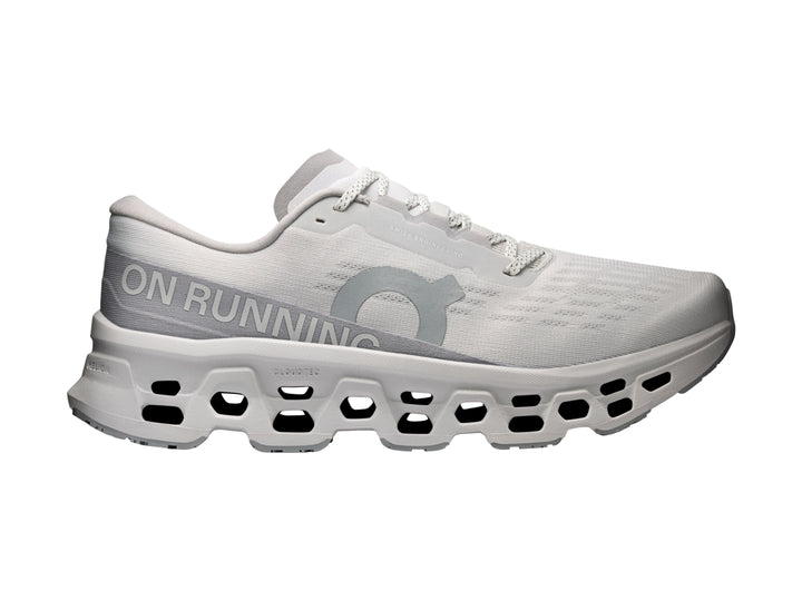 Tenis deportivos On Cloudmonster 3 en color gris claro con suela amortiguada característica.