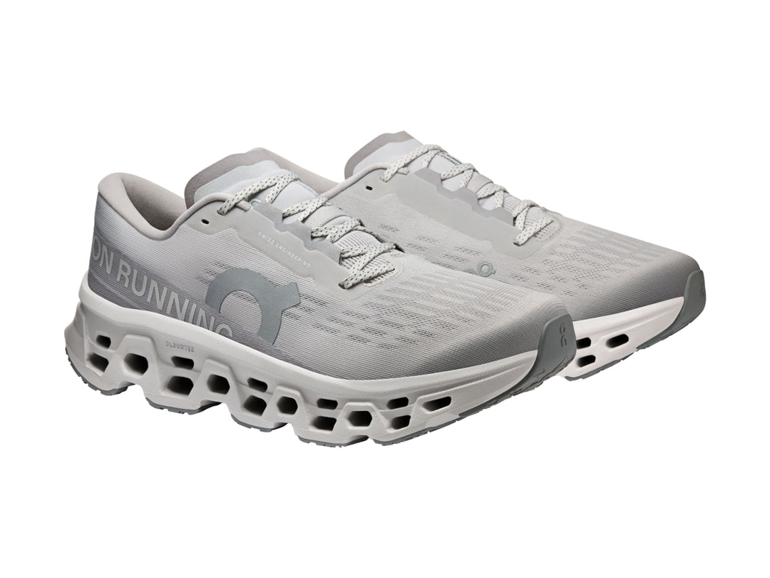 Tenis deportivos On Cloudmonster 3 en color gris claro con suela amortiguada característica.