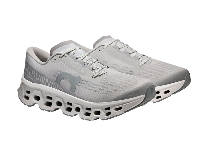 Tenis deportivos On Cloudmonster 3 en color gris claro con suela amortiguada característica.