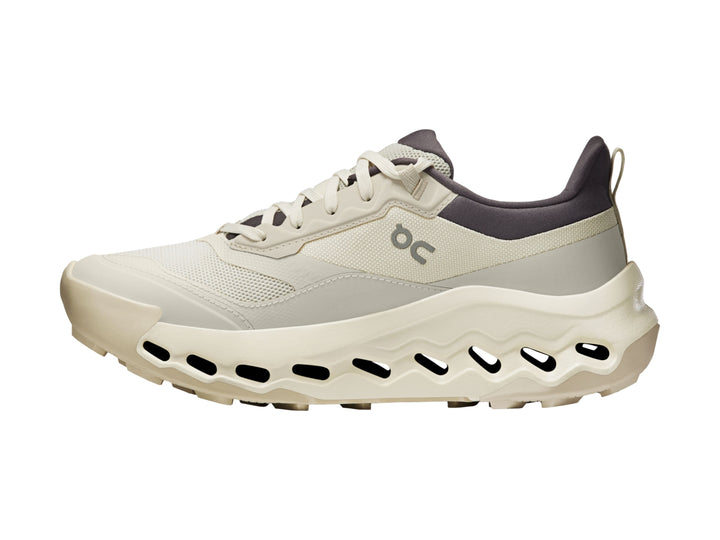 Tenis deportivos On Cloud color beige con suela gruesa y cuello en color gris oscuro.