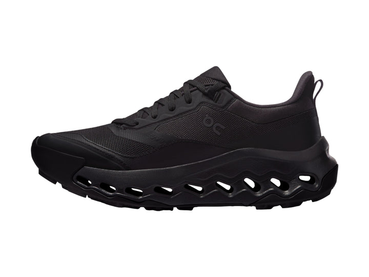 Tenis deportivos On Cloud en color negro con suela característica de huecos y parte superior de malla.