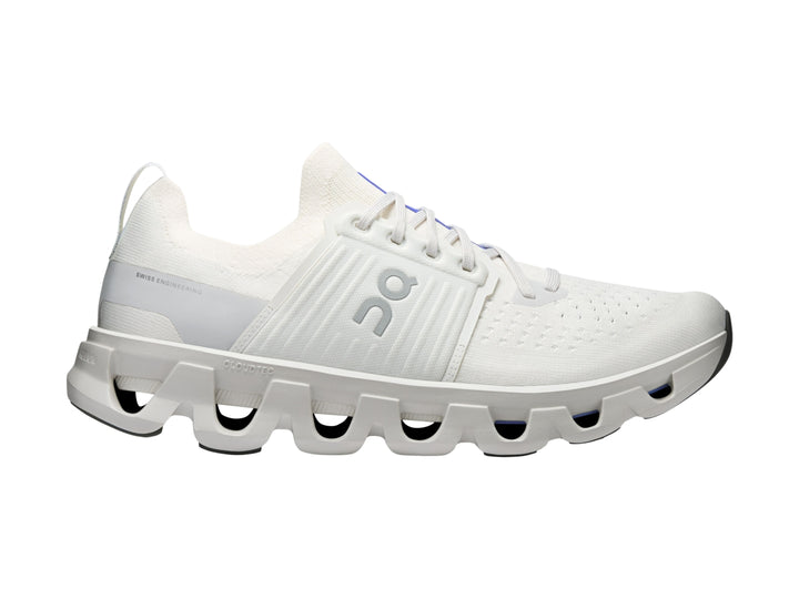 Tenis deportivos On Cloud color blanco ivory con suela amortiguada característica y detalles azules.
