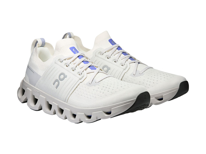 Tenis deportivos On Cloud color blanco ivory con suela amortiguada característica y detalles azules.