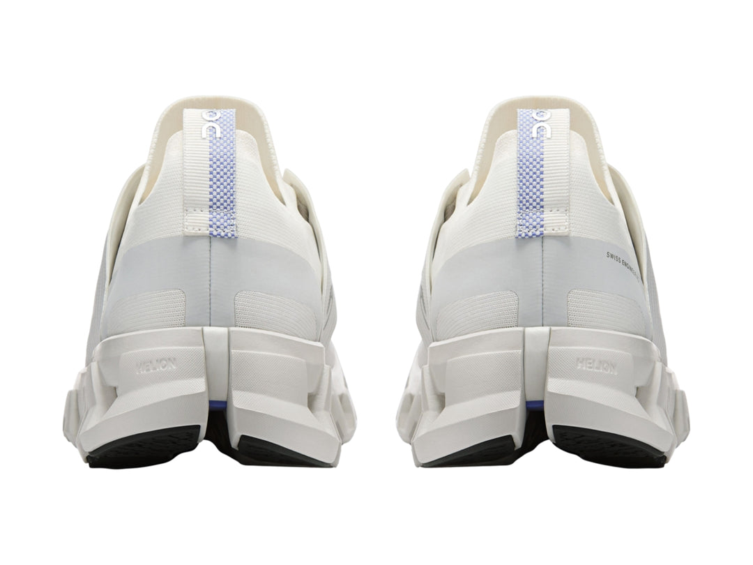 Tenis deportivos On Cloud color blanco ivory con suela amortiguada característica y detalles azules.