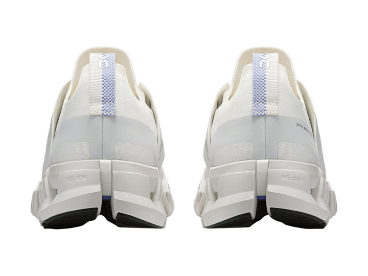 Tenis deportivos On Cloud color blanco ivory con suela amortiguada característica y detalles azules.