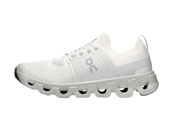 Tenis deportivos On Cloud color blanco ivory con suela amortiguada característica y detalles azules.