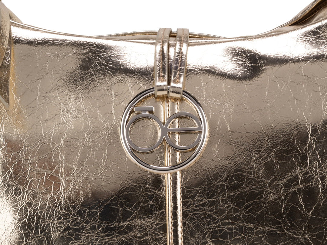 Bolsa de mano color oro metalizado marca Cloe con asa superior y logotipo circular frontal.