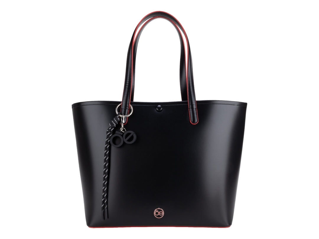 Bolsa tote color negro con bordes rojos y accesorio de borla decorativa, marca Cloe.