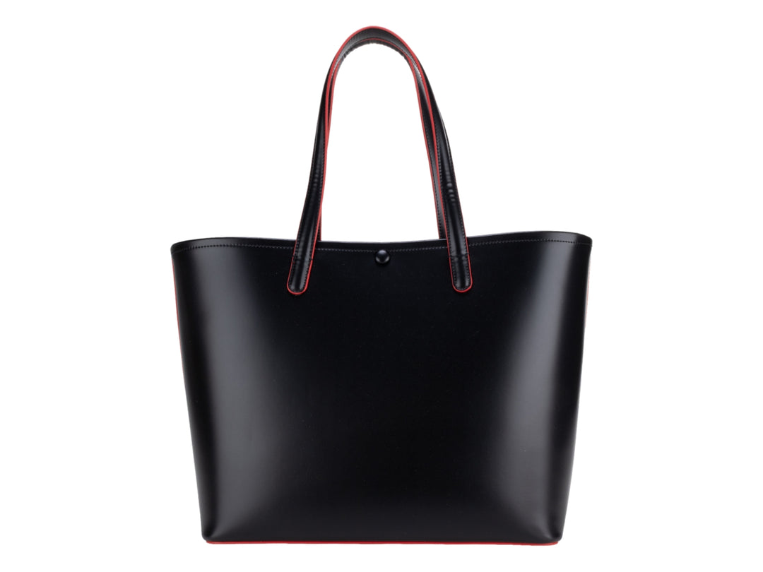 Bolsa tote color negro con bordes rojos y accesorio de borla decorativa, marca Cloe.