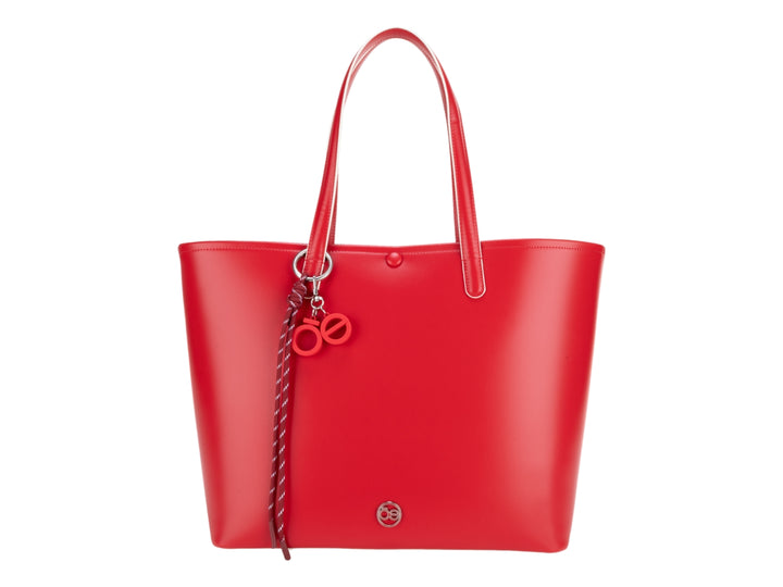 Bolsa tote de color rojo vibrante con asas largas y accesorio decorativo colgante.