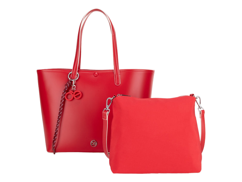 Bolsa tote de color rojo vibrante con asas largas y accesorio decorativo colgante.