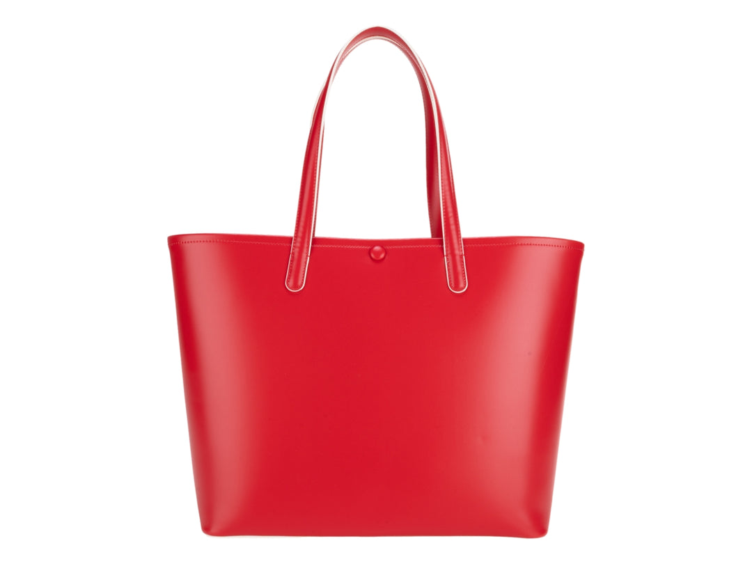 Bolsa tote de color rojo vibrante con asas largas y accesorio decorativo colgante.