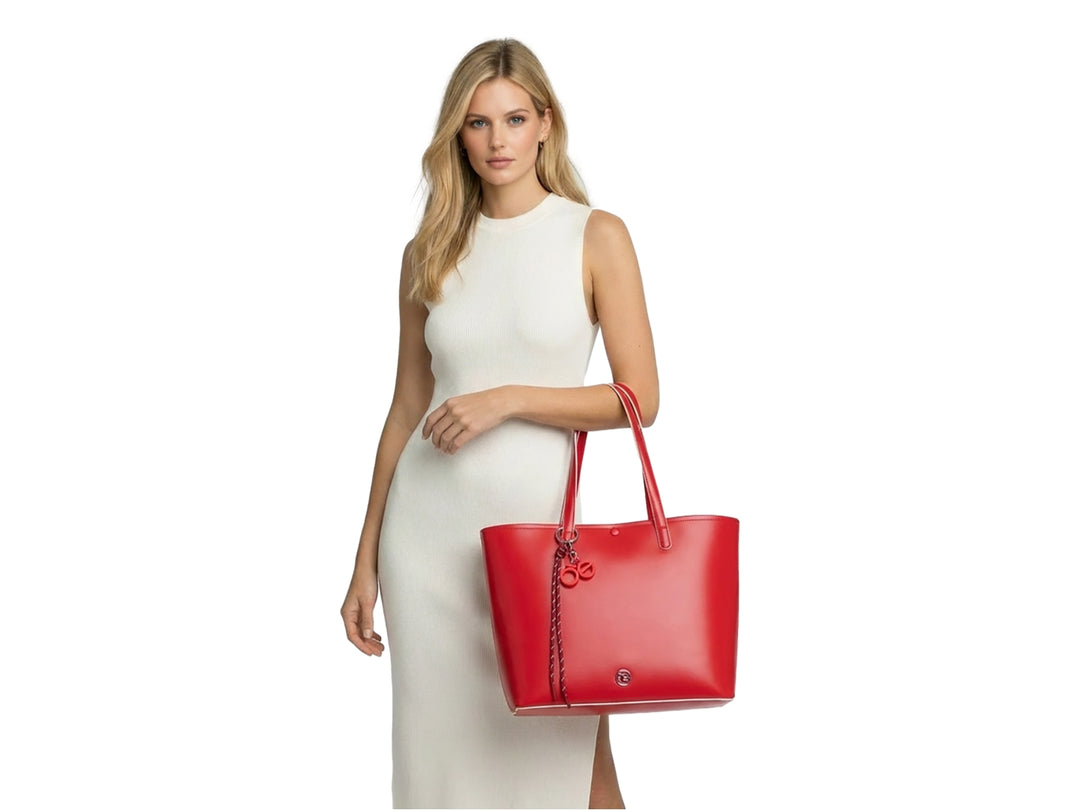 Bolsa tote de color rojo vibrante con asas largas y accesorio decorativo colgante.
