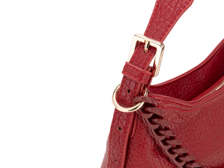 Bolso pequeño rojo con textura rugosa, detalle de cadena frontal y correa para el hombro.