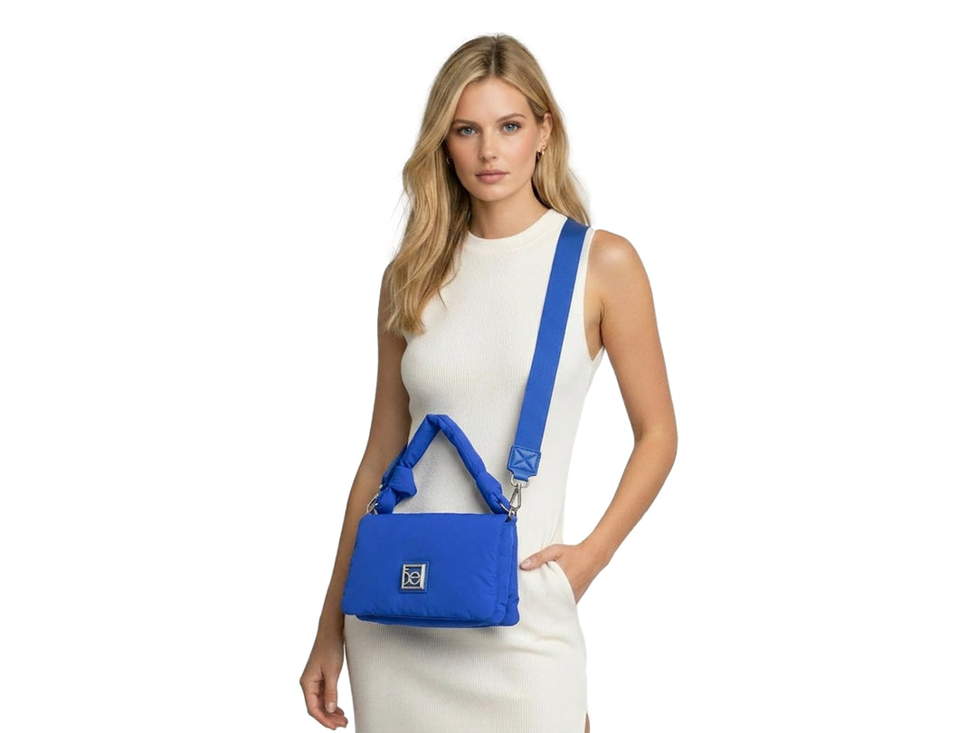 Bolso pequeño Cloe color azul con diseño acolchado, asa superior y correa ajustable.