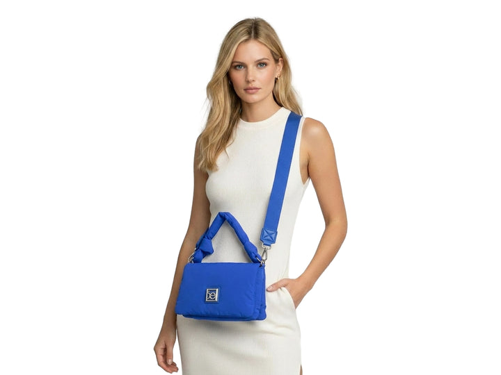 Bolso pequeño Cloe color azul con diseño acolchado, asa superior y correa ajustable.
