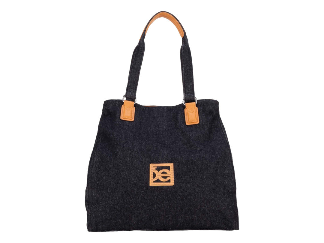 Bolsa tote color negro con detalles y asas en color naranja.