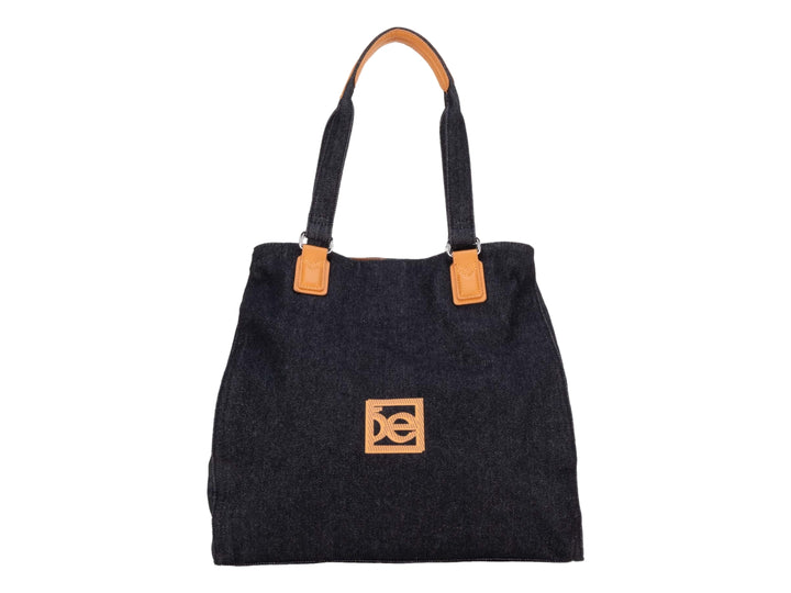 Bolsa tote color negro con detalles y asas en color naranja.