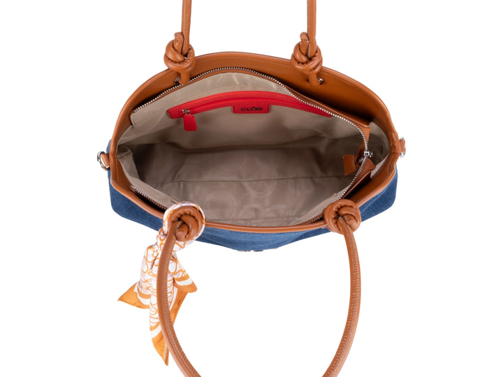 Bolsa Cloe azul con detalles en marrón y un pañuelo decorativo anudado en el asa.