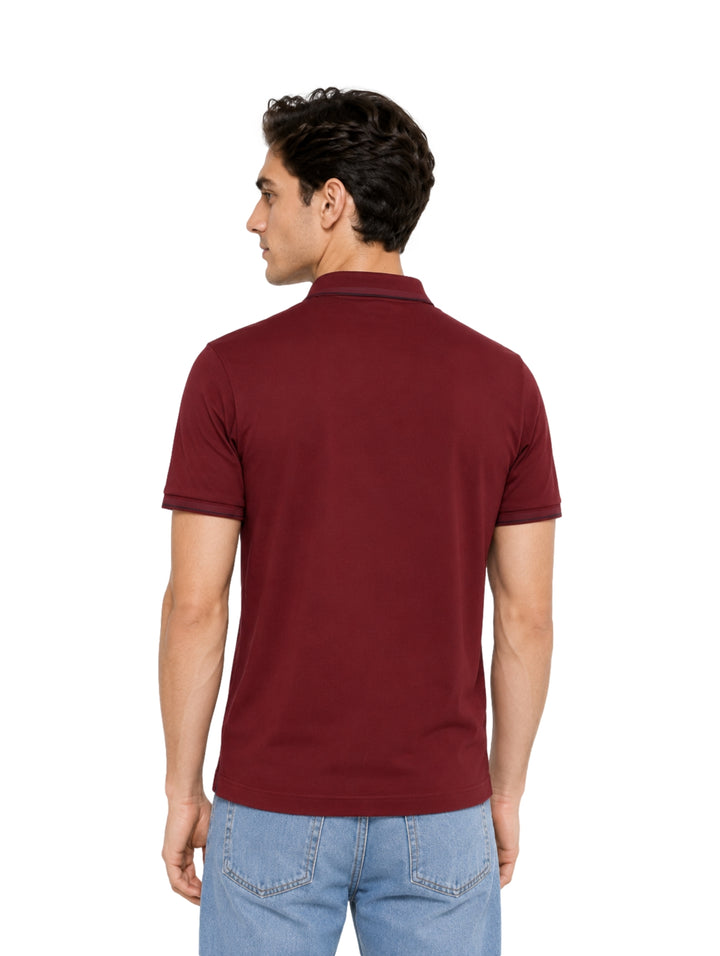 Hombre vistiendo una playera polo de color rojo púrpura marca Bratto.