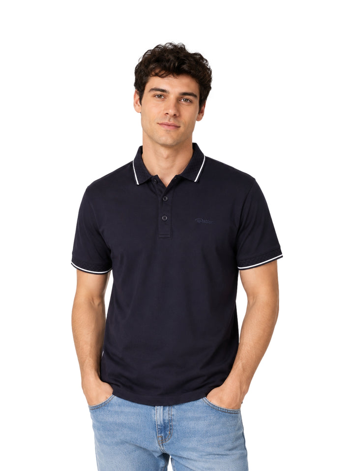 Hombre vistiendo playera polo color azul rey con detalles blancos en cuello y mangas.