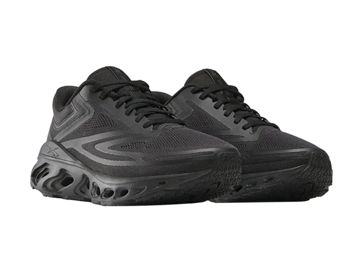 Tenis deportivos Reebok Fuel Flex Run color negro con suela perforada y malla transpirable.