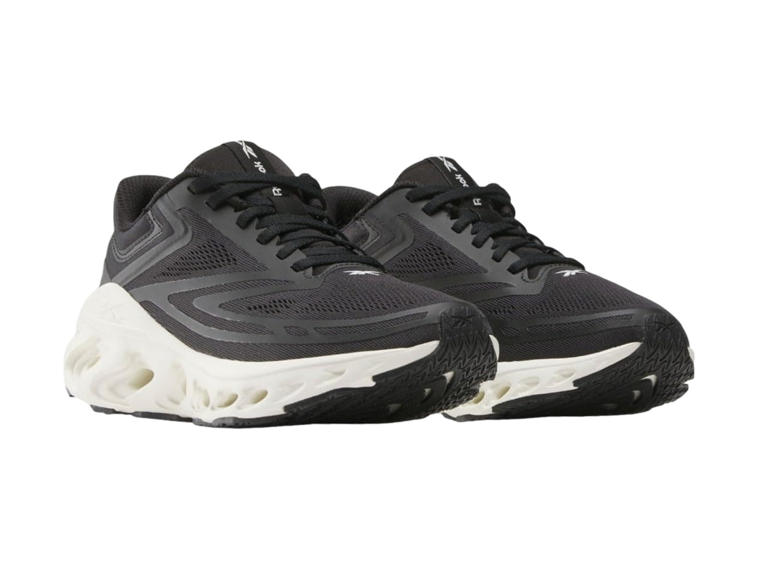 Tenis deportivos Reebok color negro con suela blanca gruesa y diseño ergonómico.