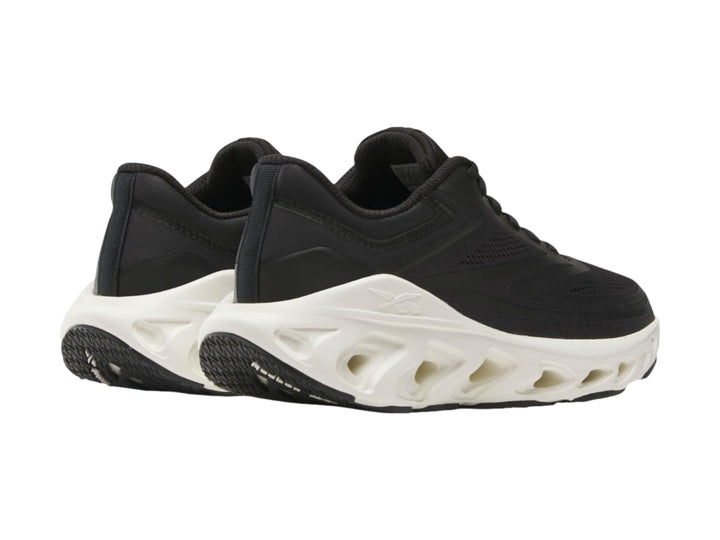 Tenis deportivos Reebok color negro con suela blanca gruesa y diseño ergonómico.