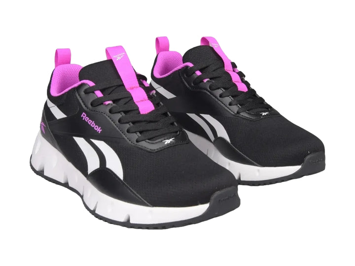 Tenis deportivos Reebok color negro con suela blanca y detalles en rosa.