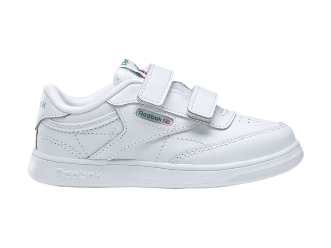 Tenis blancos Reebok para niños con cierre de velcro y suela blanca.