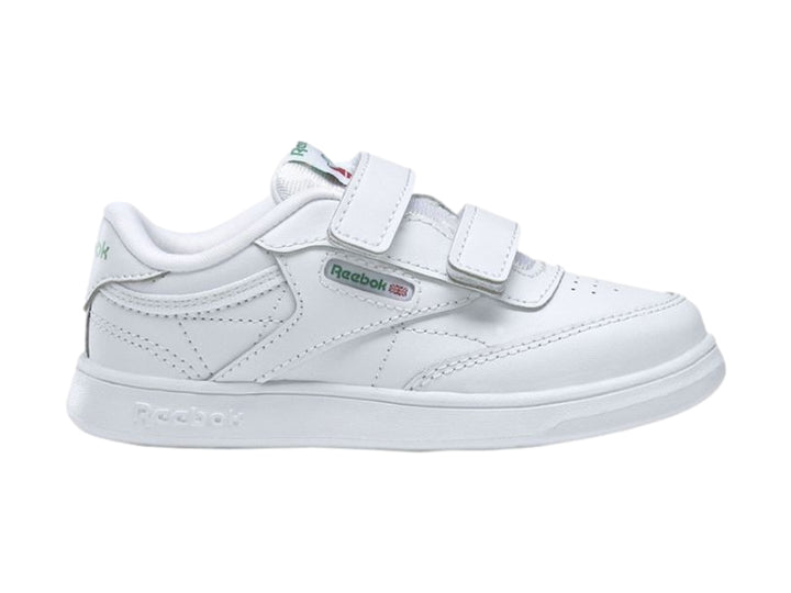 Tenis blancos Reebok para niños con cierre de velcro y suela blanca.