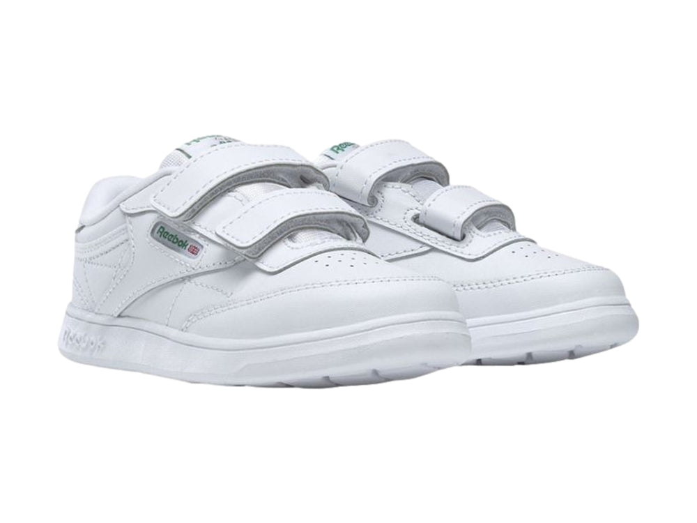 Tenis blancos Reebok para niños con cierre de velcro y suela blanca.