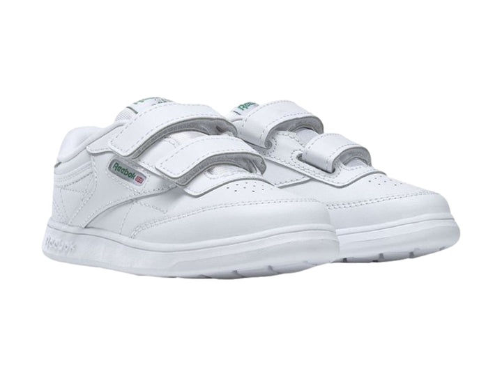 Tenis blancos Reebok para niños con cierre de velcro y suela blanca.