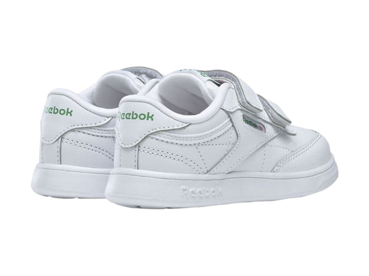 Tenis blancos Reebok para niños con cierre de velcro y suela blanca.