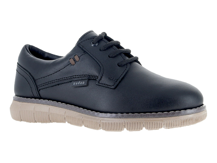 Zapato infantil color negro con cordones y suela gruesa en tono beige.