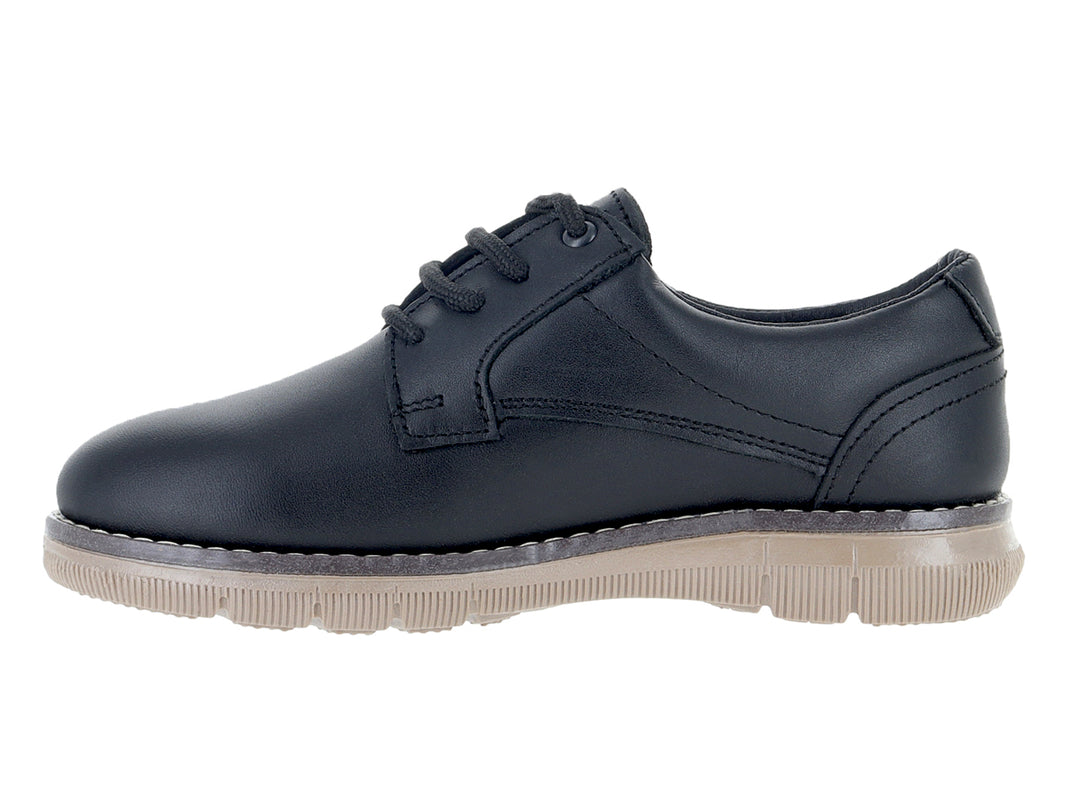 Zapato infantil color negro con cordones y suela gruesa en tono beige.