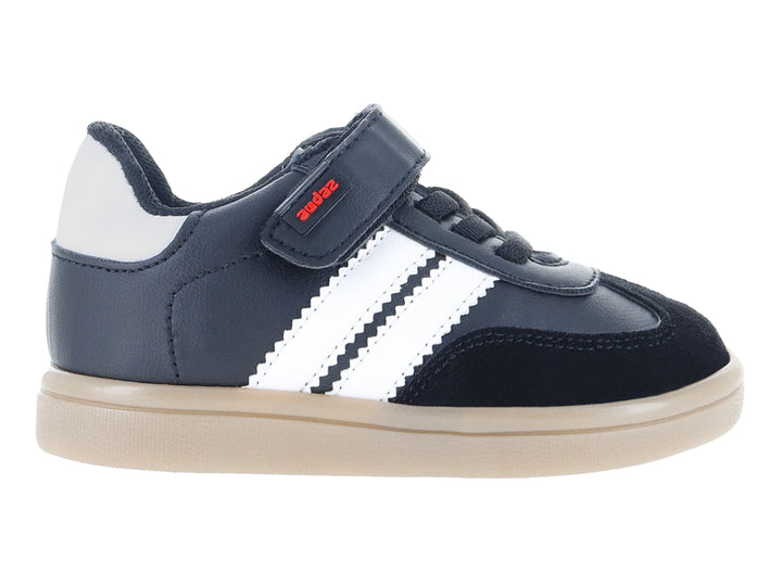 Tenis infantiles color negro con franjas blancas laterales y suela beige.