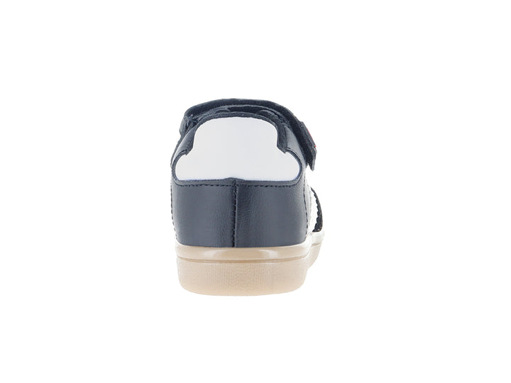 Tenis infantiles color negro con franjas blancas laterales y suela beige.