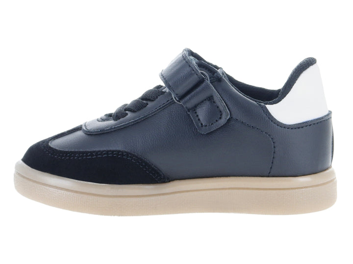 Tenis infantiles color negro con franjas blancas laterales y suela beige.