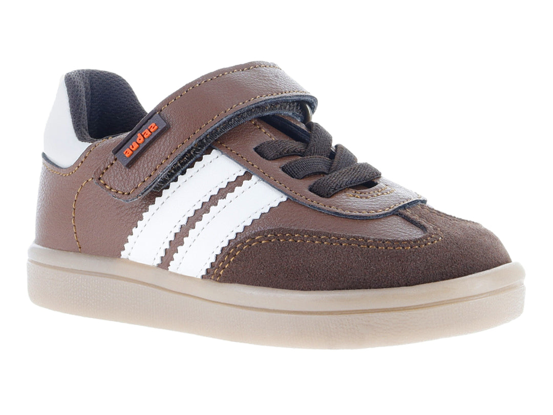 Tenis infantiles color café claro con franjas blancas laterales y ajuste de velcro.