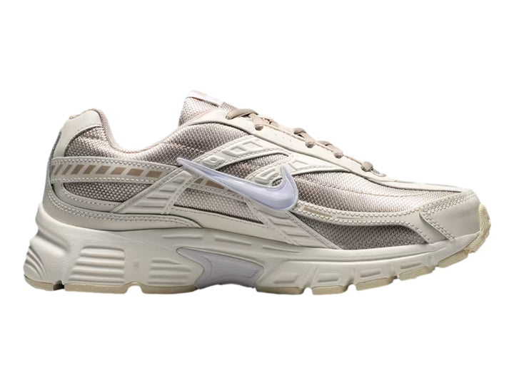 Tenis Nike Initiator color beige y blanco con suela gruesa, vista lateral.